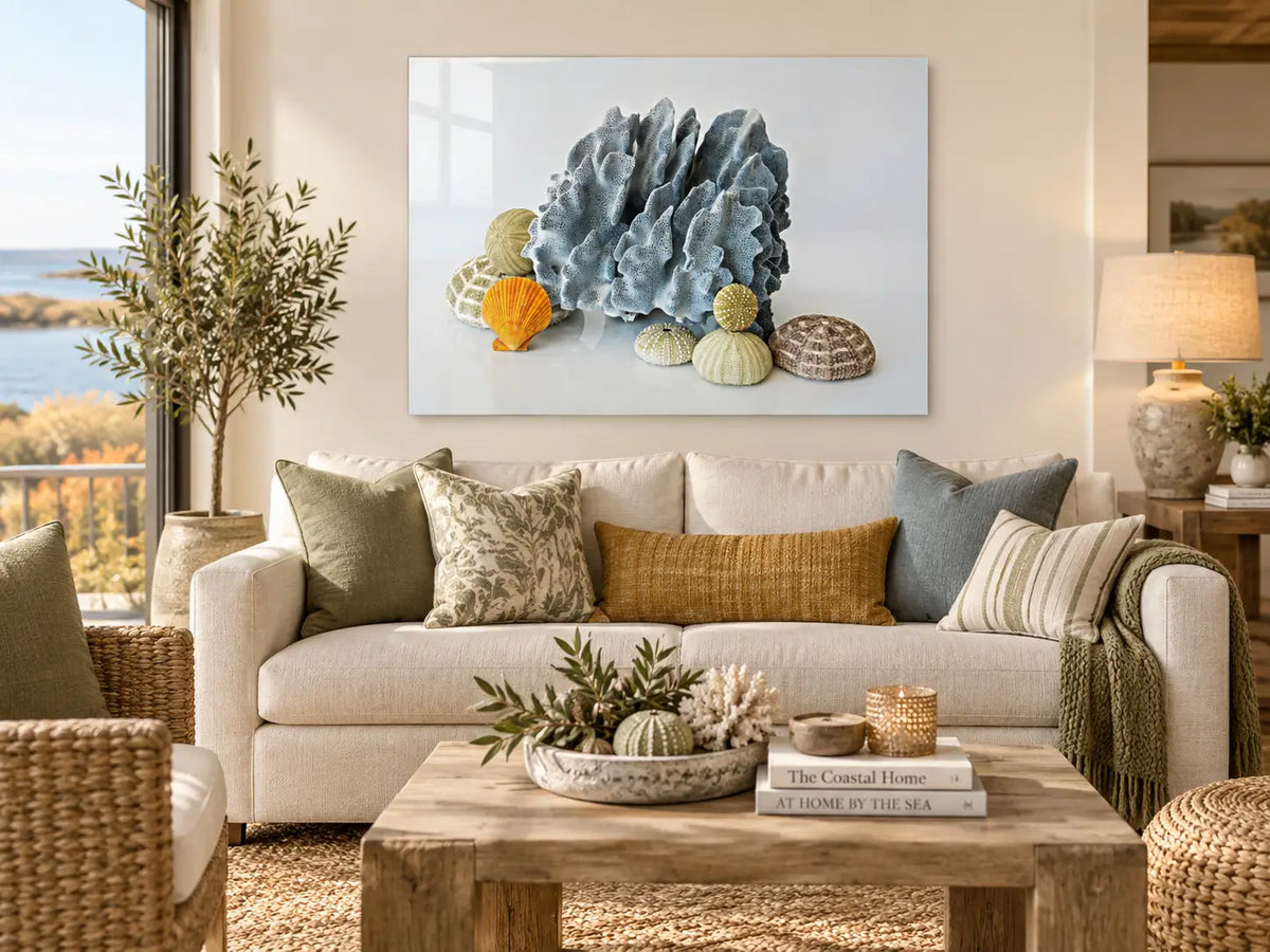 Blue Coral & Sea Urchins coastal glass print displayed in a modern living room with soft blue, olive, and warm neutral coastal accents.