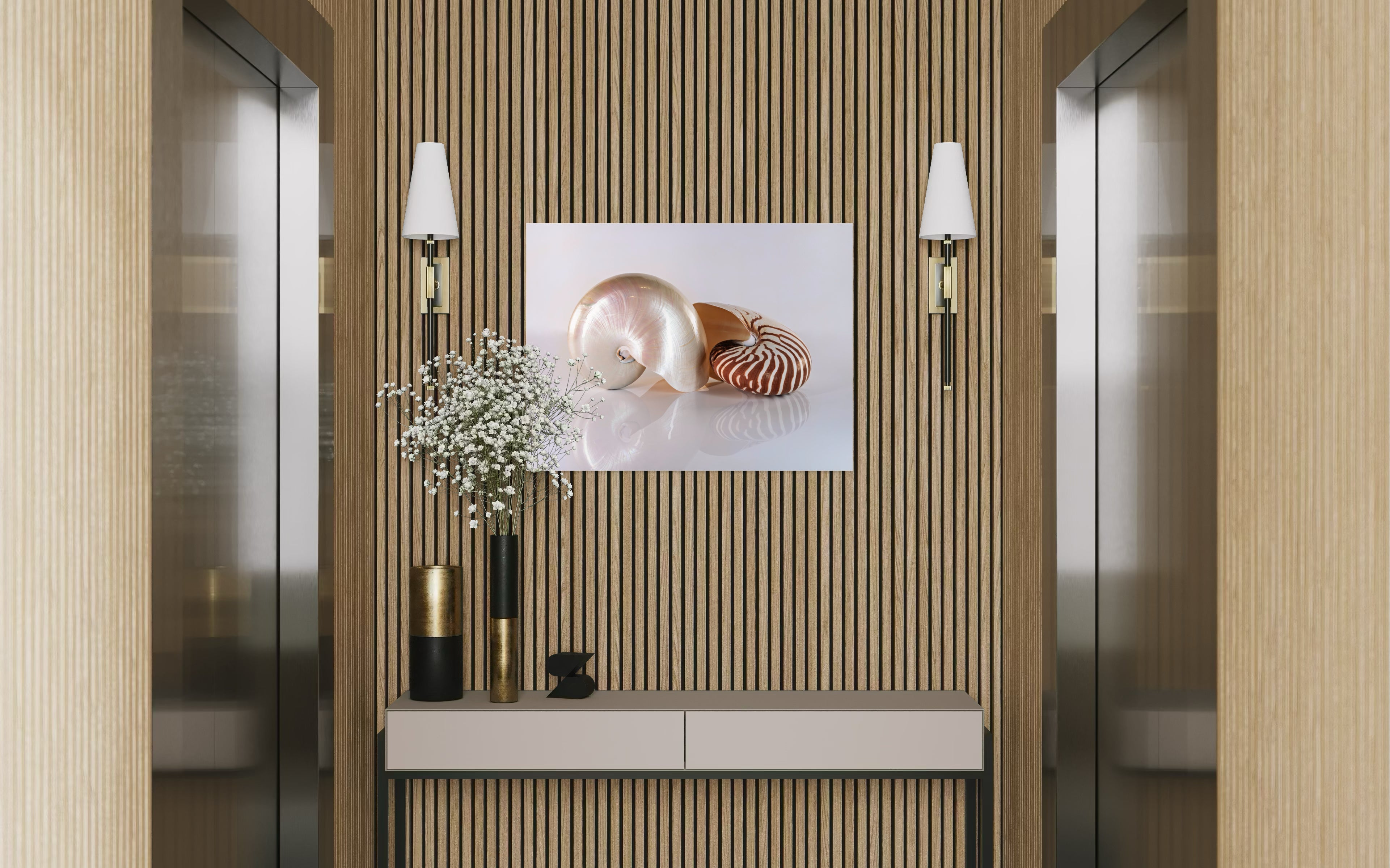 Modern wall decor: glass print of two chambered nautilus shells on reflective surface above console with sconces in elevator lobby