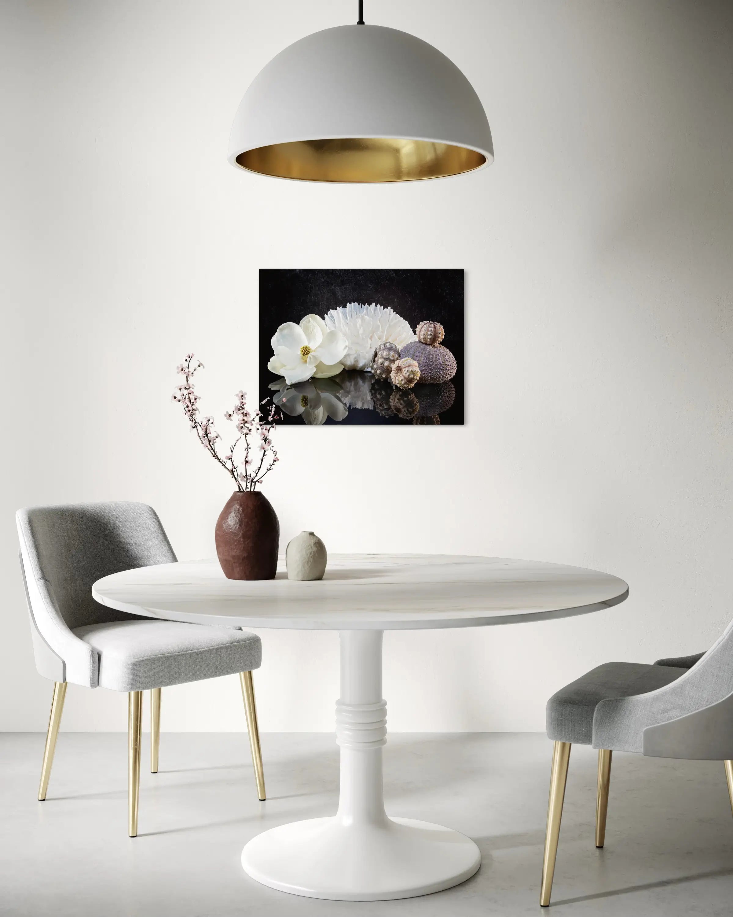Glass print of a magnolia blossom, poca coral and sea urchins on a reflective black background, modern dining decor.