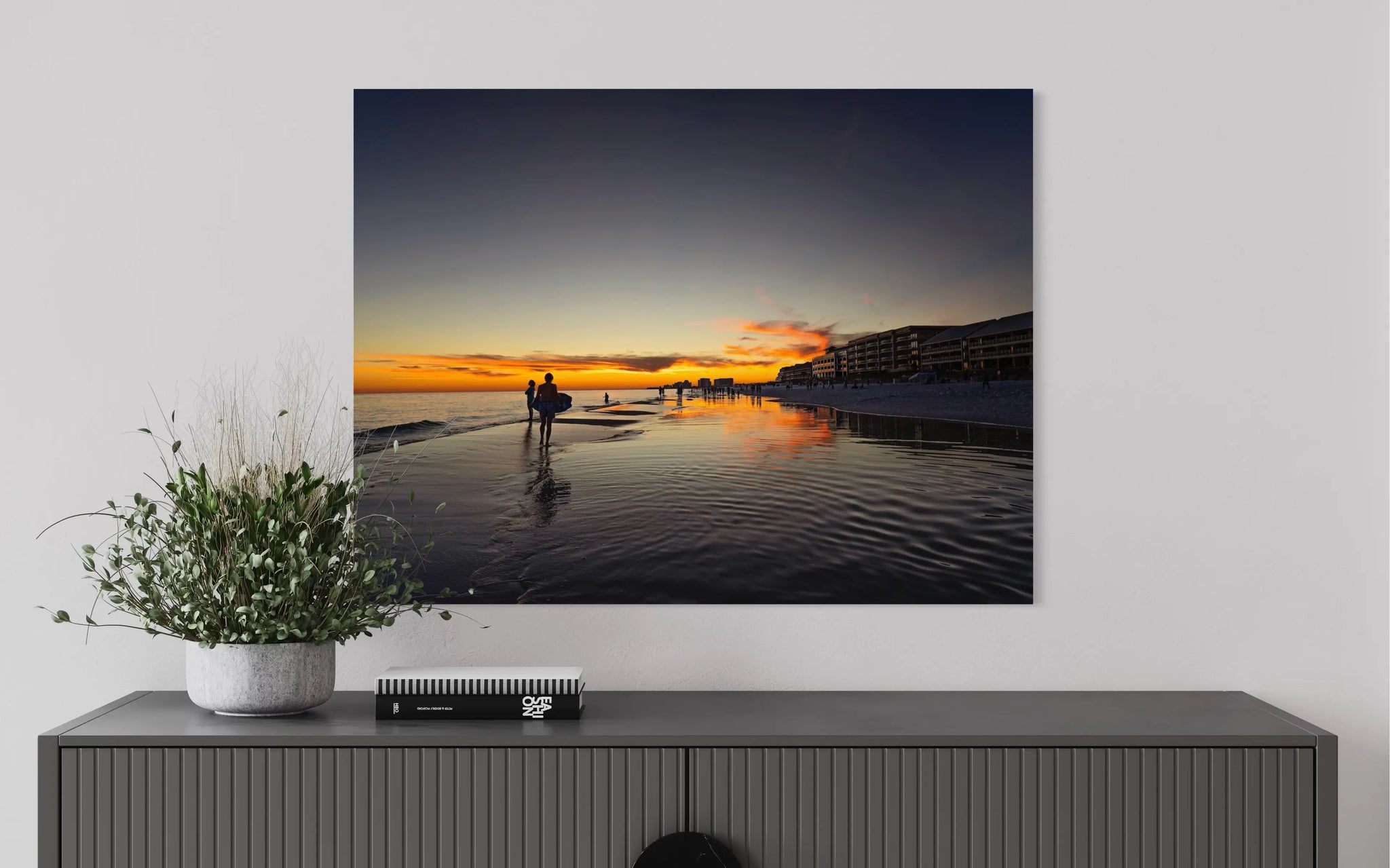 Coastal glass print of Miramar Beach sunset with beachgoers and reflections, above sideboard for coastal decor