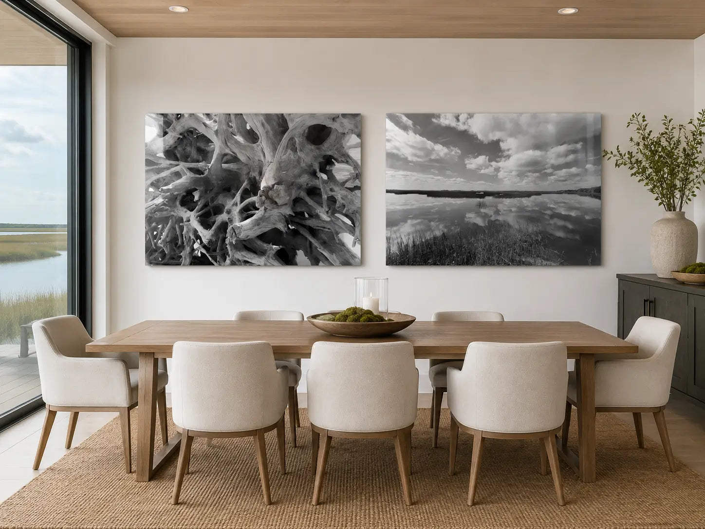 Black-and-white driftwood and Cumberland Island marsh glass prints displayed above a warm neutral coastal dining table.