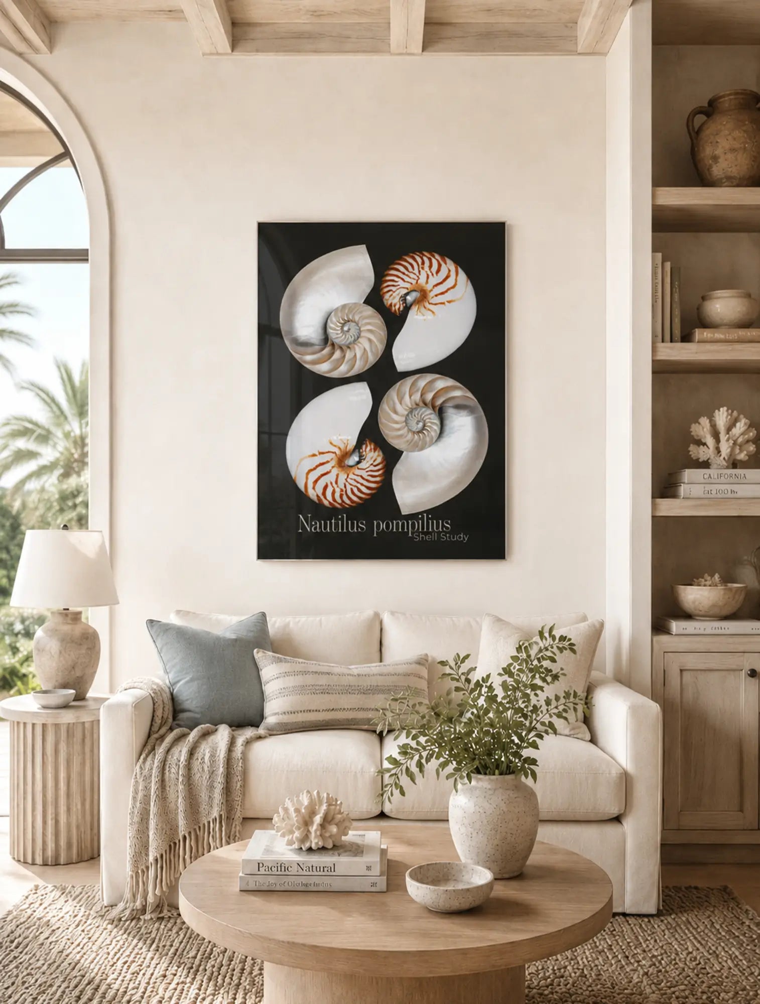 Coastal living room with a Nautilus shell glass print on the wall, beige sofa, and decorative items.