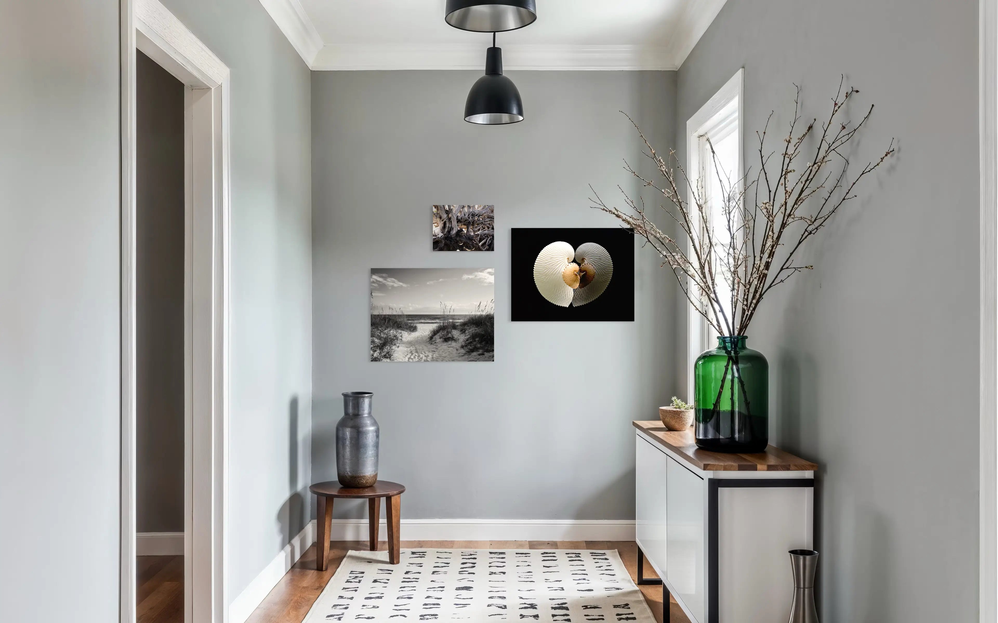 Entryway coastal gallery wall – driftwood texture print paired with coral and seashell coastal wall decor.
