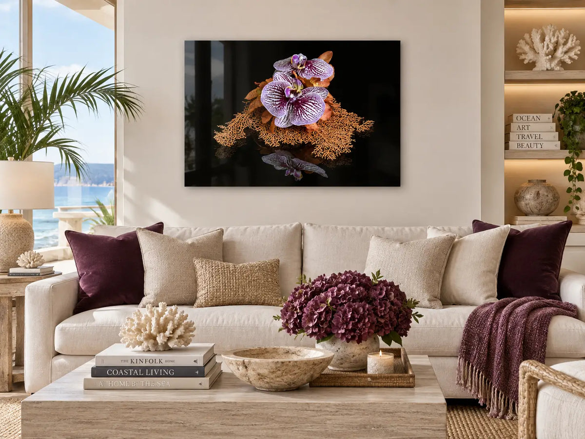 Sea fan and orchid glass print displayed above a sofa in a modern coastal living room.