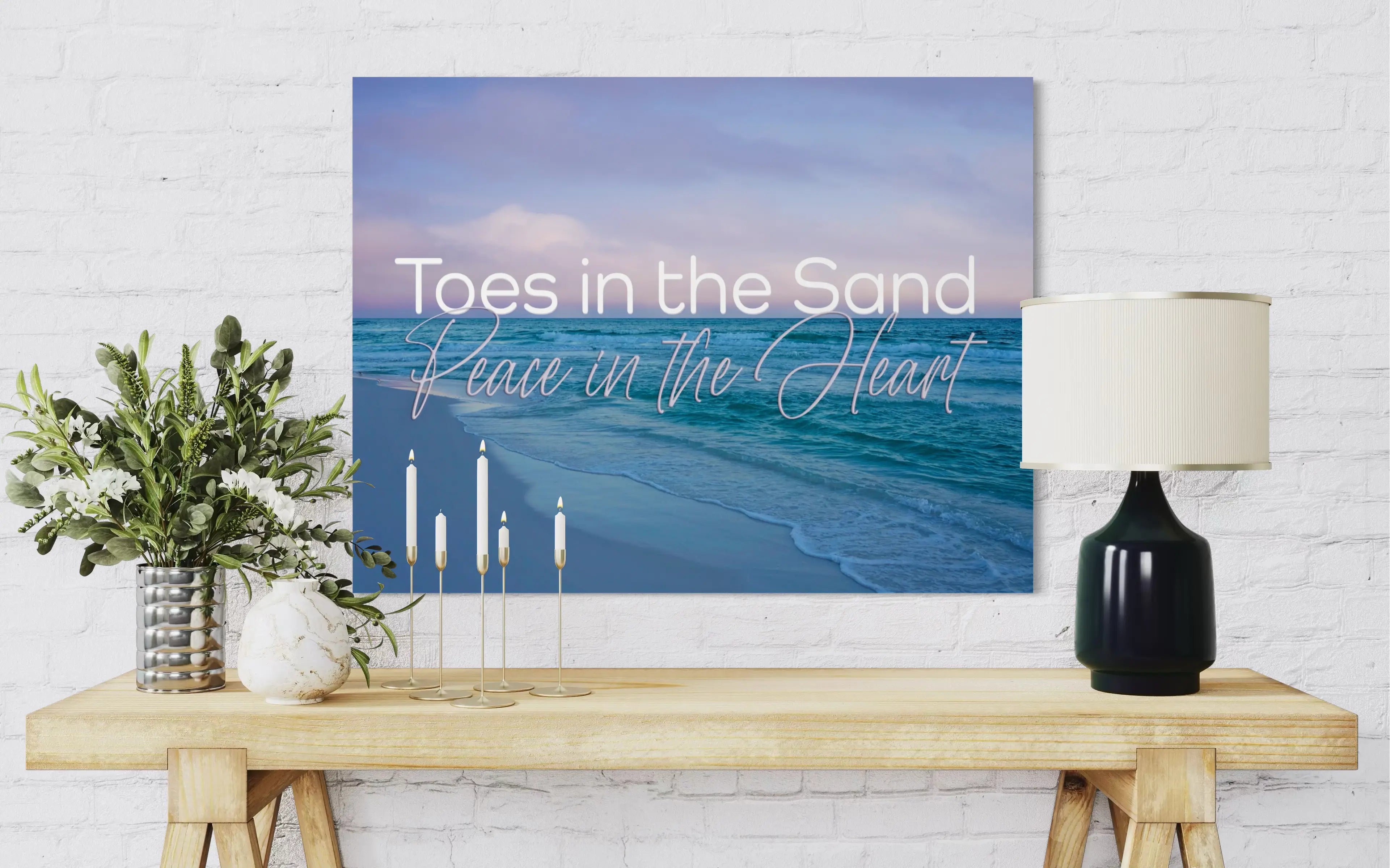 Toes in the Sand Coastal Glass Print – Peace in the Heart beach wall art styled above a wood table with candles, modern coastal décor inspiration.