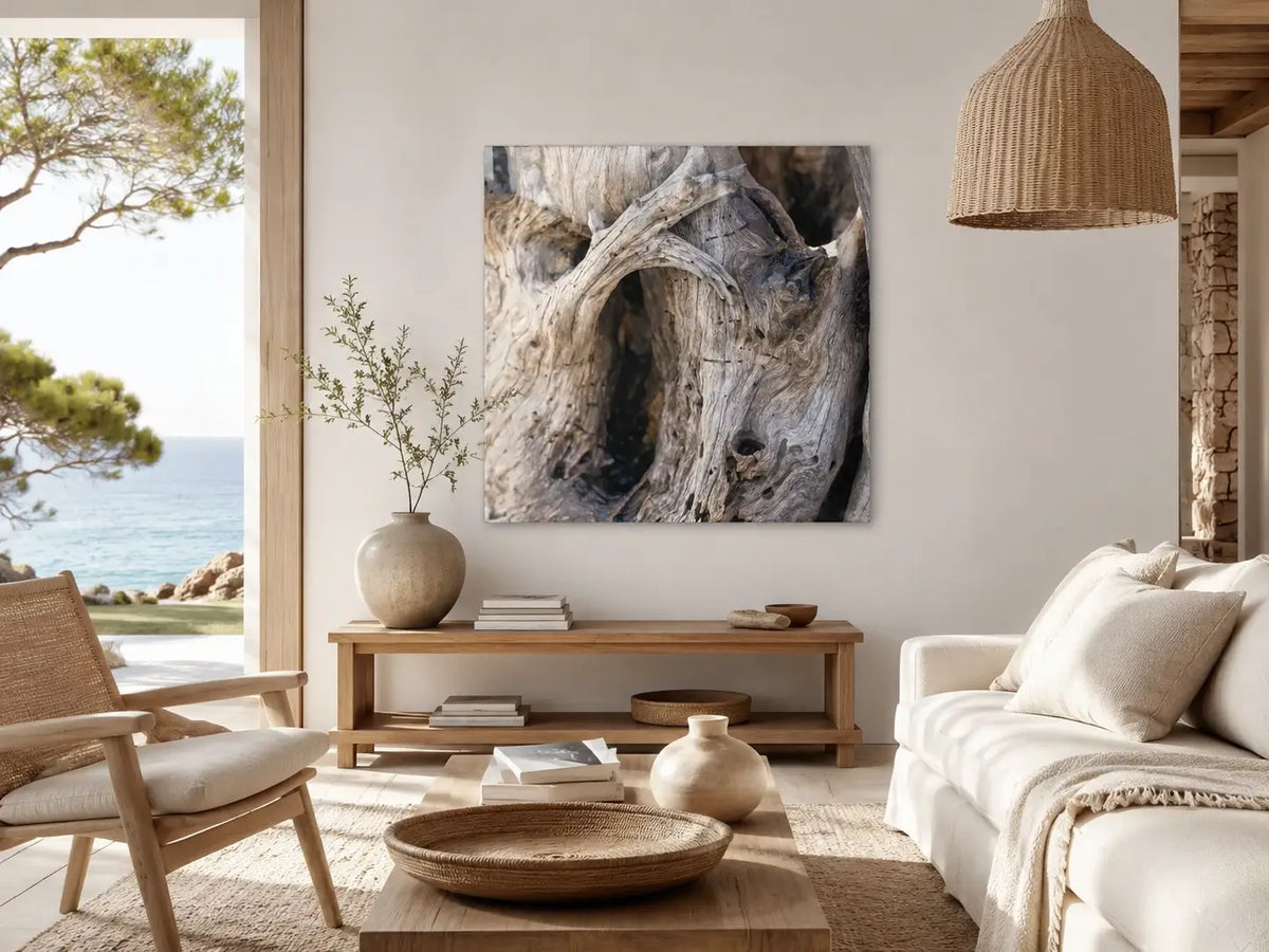 Warm modern biophilic coastal living room with a driftwood glass wall print, light oak furniture, woven textures, soft neutral seating, and an ocean view.