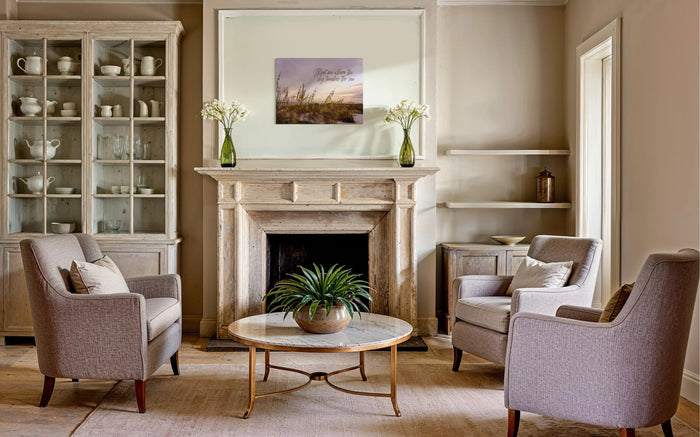 Warm coastal cottage living room with sea oats sunset coastal glass print above rustic fireplace.