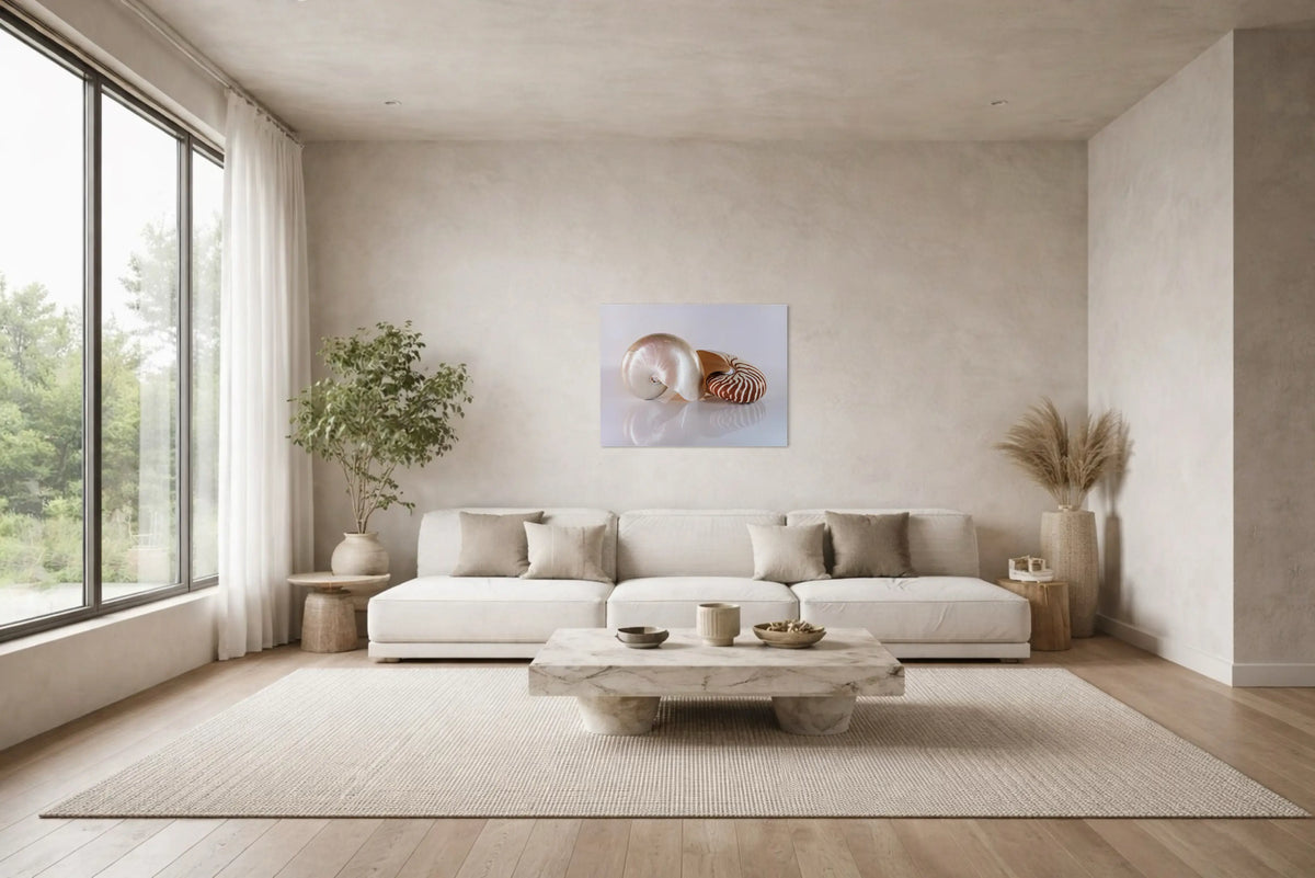 Japandi coastal living room with low neutral sectional, travertine coffee table, plaster walls, and single minimalist shell art print centered above the sofa.