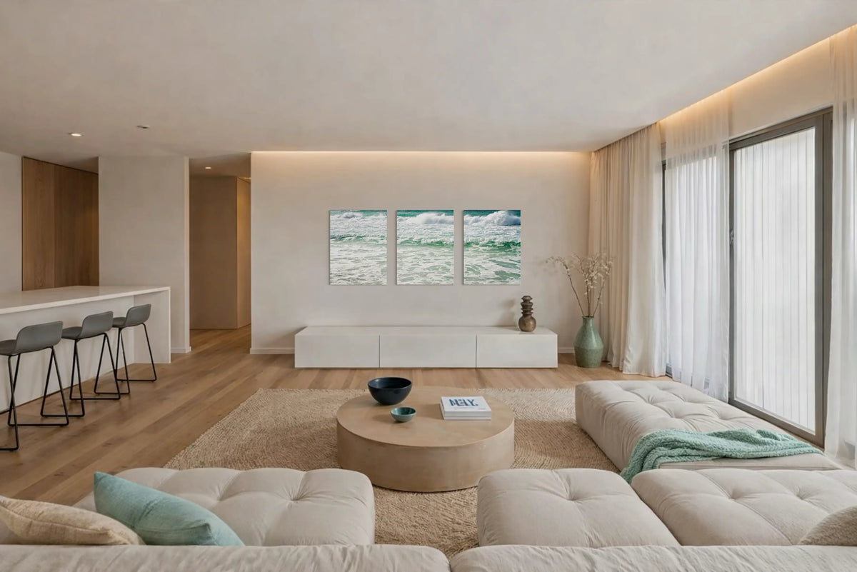 A modern coastal living space in soft sand and seafoam tones featuring ocean-inspired artwork that embodies the color psychology of coastal calm