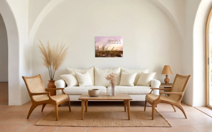 Bright coastal living room with natural rattan chairs, jute rug, and a recycled glass wall print reading ‘Meet me where the sky touches the sea,’ styled in sustainable, eco-coastal décor.