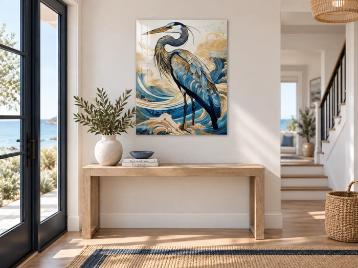 Heron glass wall art displayed above a light wood console in a restrained modern coastal entryway with navy and blue accents.