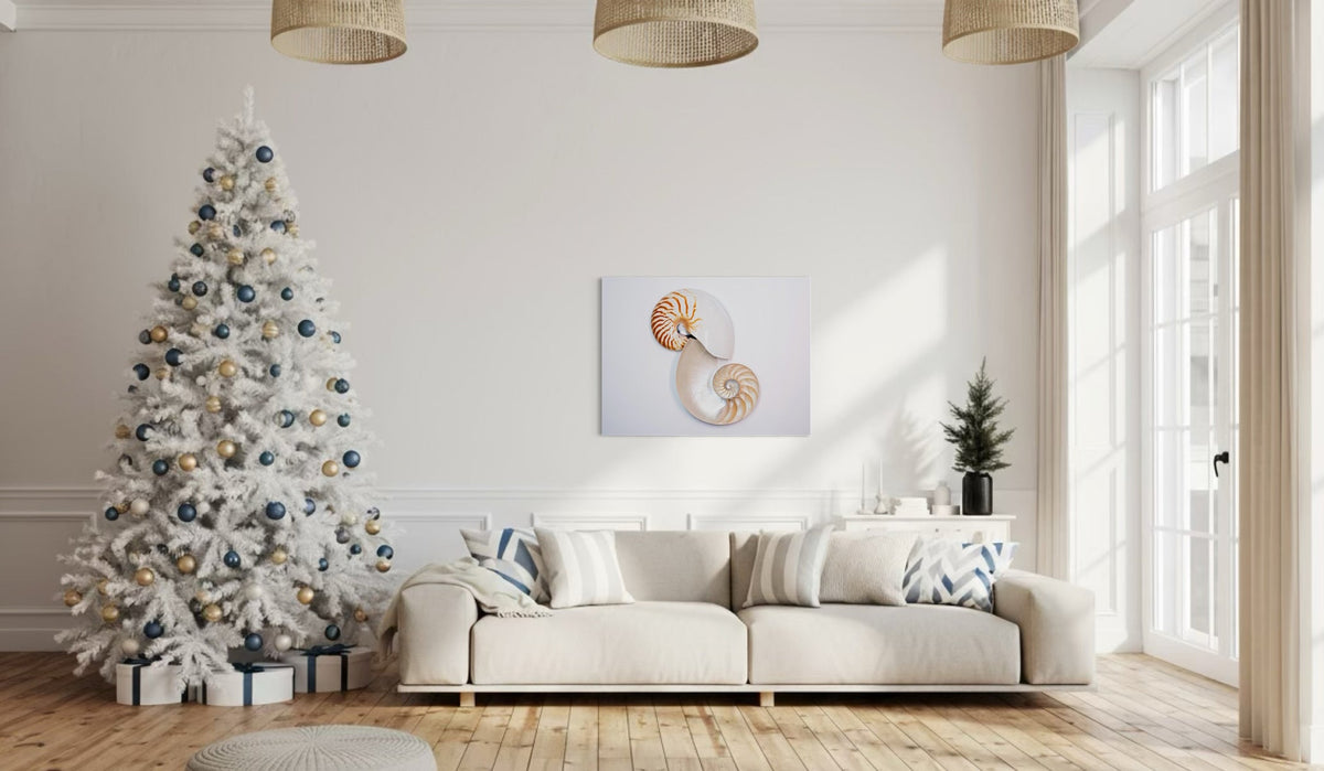 Coastal holiday living room with white Christmas tree and Nautilus glass print — art that captures harmony, balance, and the meaning of giving