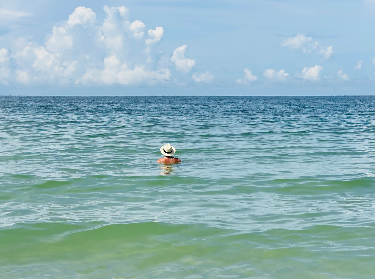 Person standing quietly in the ocean, reflecting the meaning of thalassophile and a deep connection to the sea.