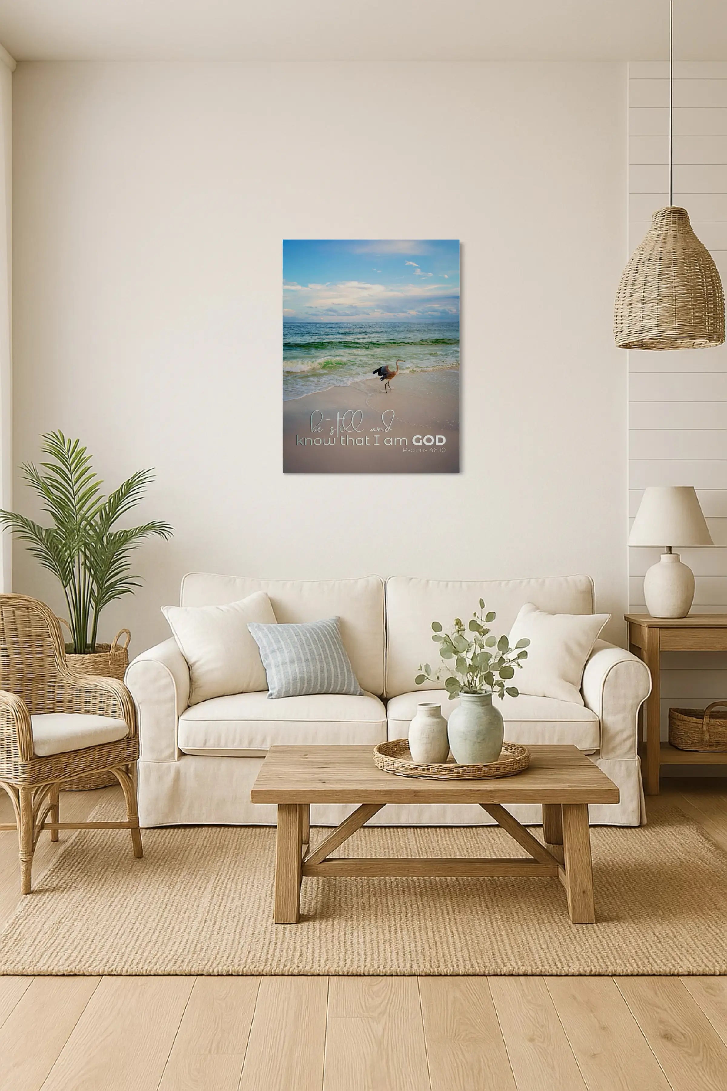 Inspirational heron coastal glass print with Psalm 46:10 scripture, displayed above a sofa in a coastal living room, Christian wall art bringing peace and faith to coastal home décor.