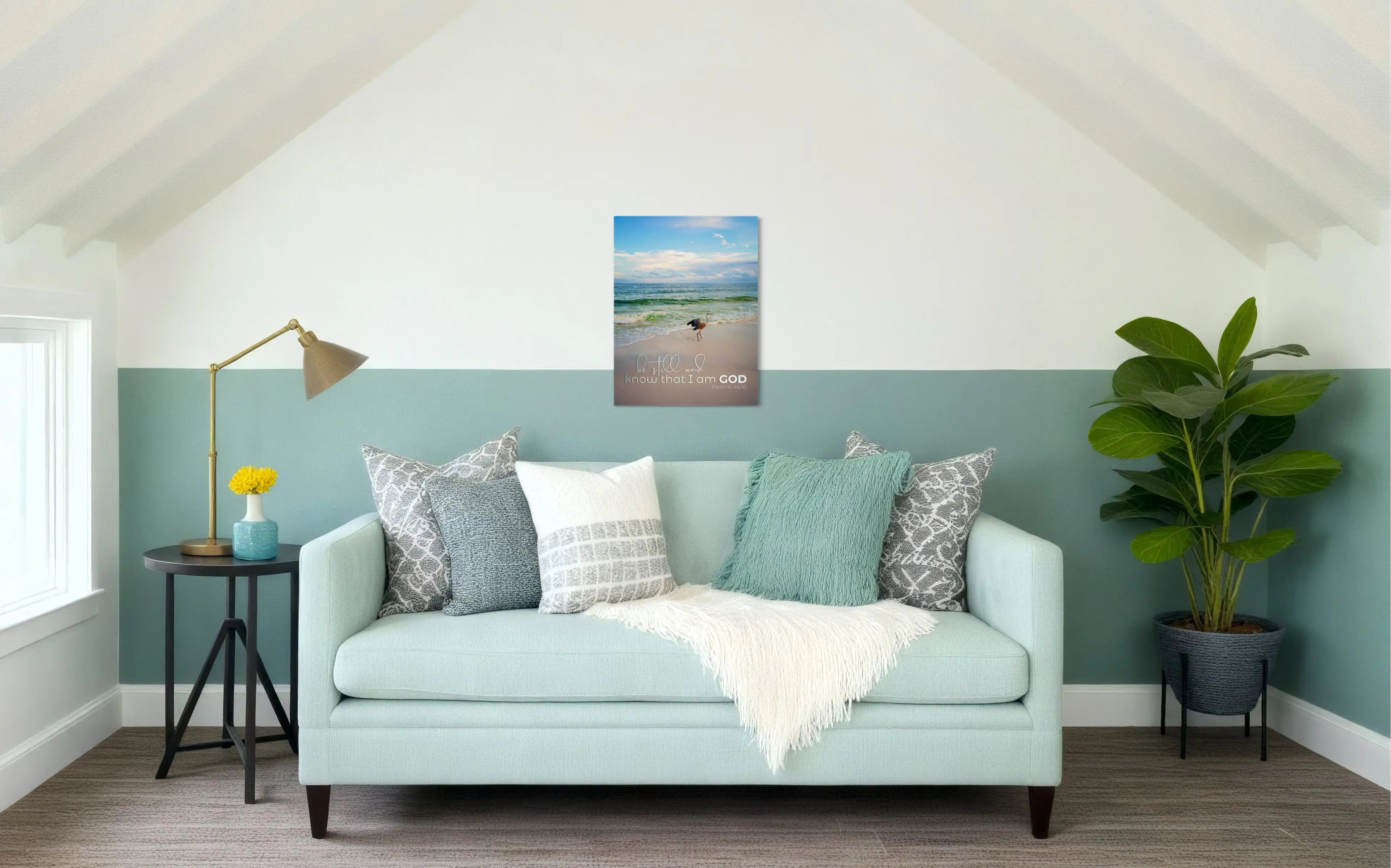 Inspirational heron coastal glass print with Psalm 46:10 scripture, displayed above a sofa in a coastal living room, Christian wall art