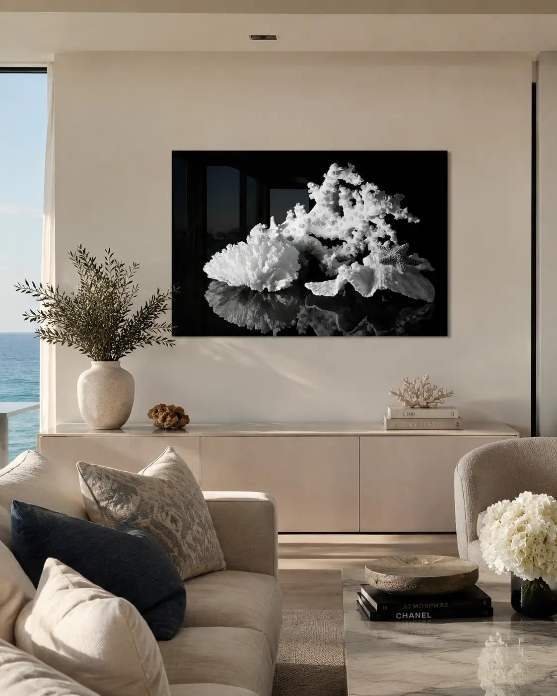 Modern coastal living room with a black and white glass print of octopus coral , other white coral and a starfish.