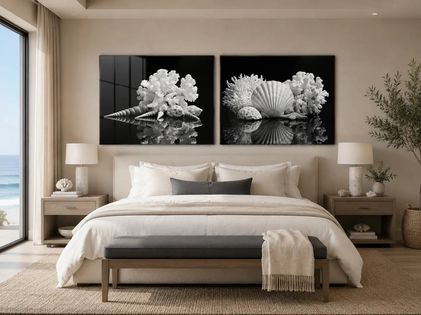Two black-and-white seashell and coral glass prints displayed above a neutral bed in a serene modern coastal bedroom with charcoal accents and an ocean view.