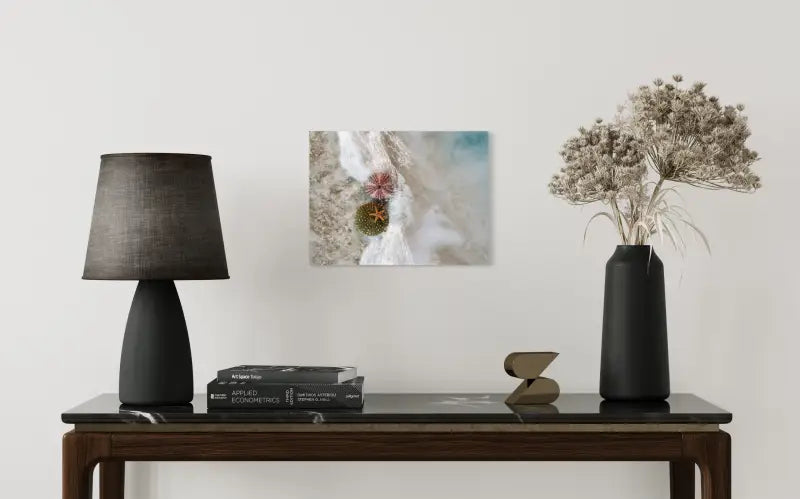 Seashell glass print with starfish and sea urchins in foamy waves and sand, coastal home decor-above table