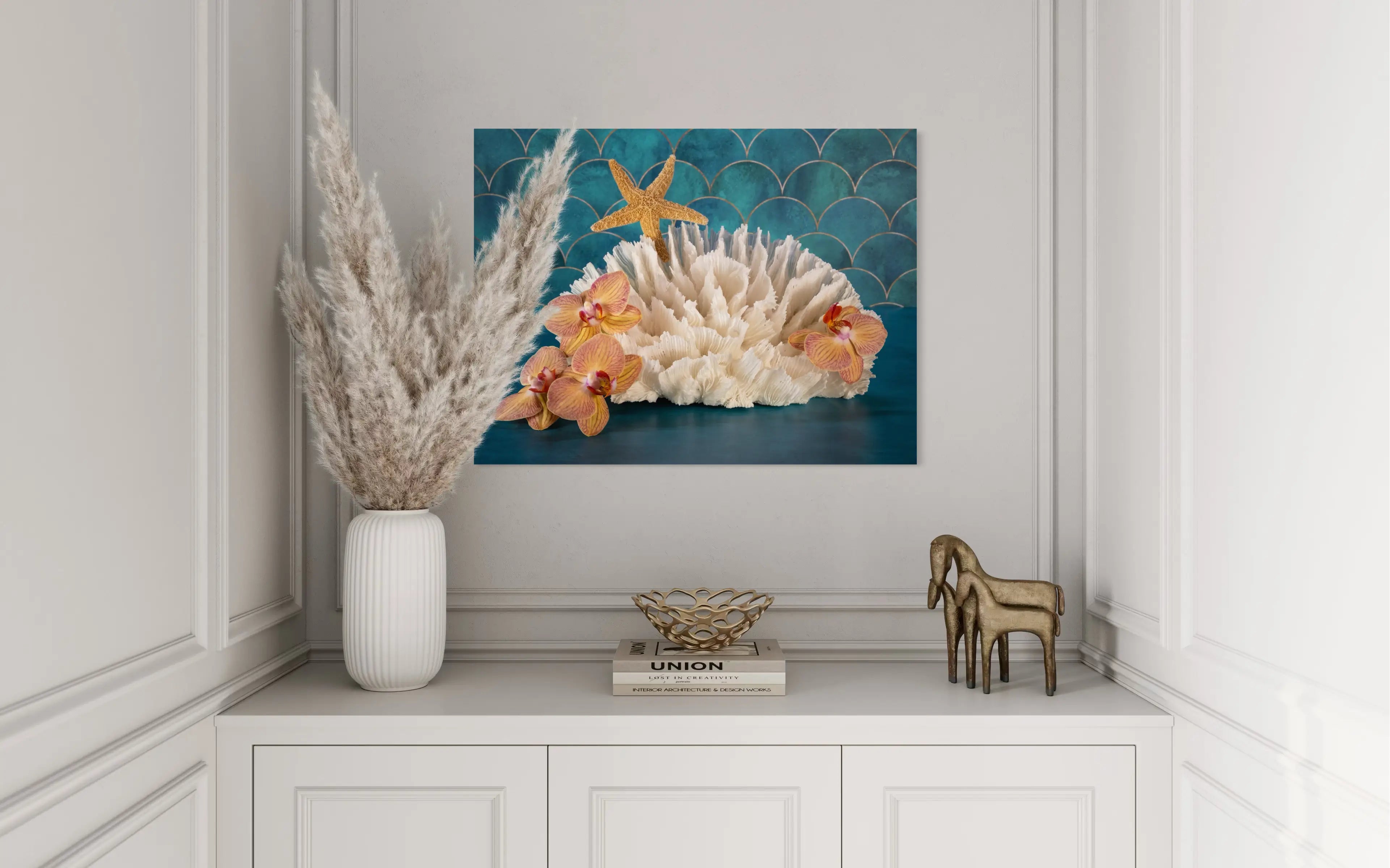 Vibrant tropical glass print of orchids, poca coral and a starfish on a colorful blue background that evokes the sea. in modern coastal decor.