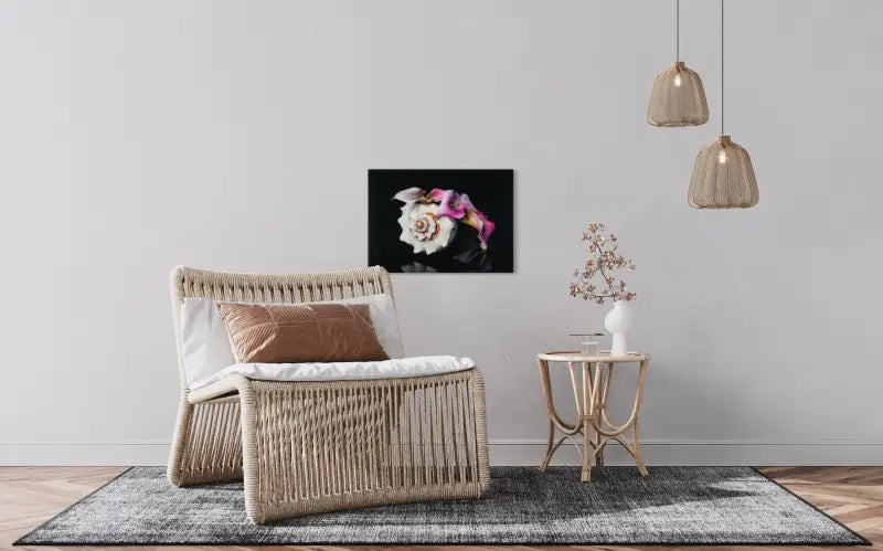 Pink calla lily and Triton’s Trumpet seashell on black coastal glass print, elegant botanical art, in coastal sitting area