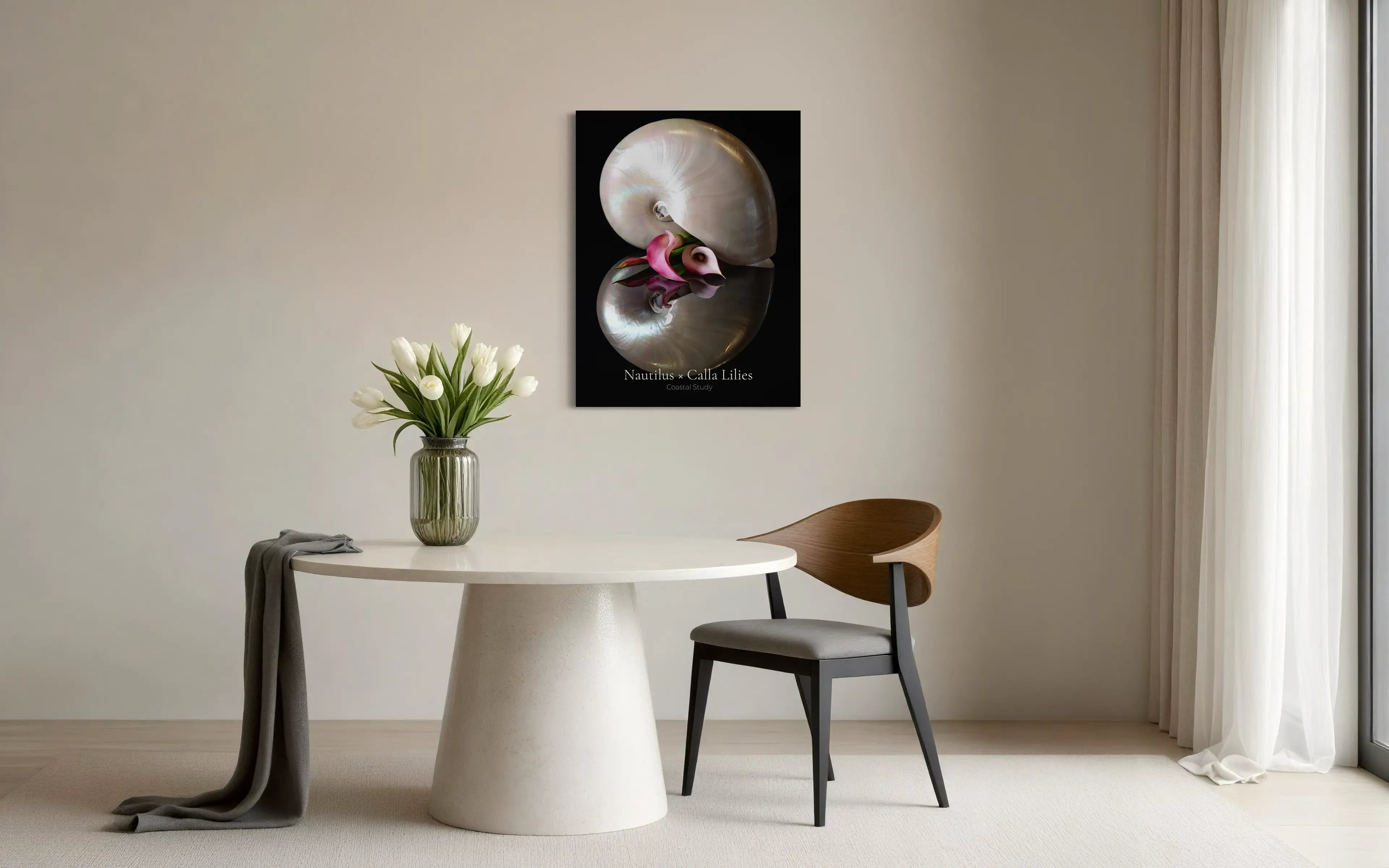 Nautilus shell wall art with calla lily displayed above a dining table in a modern coastal interior
