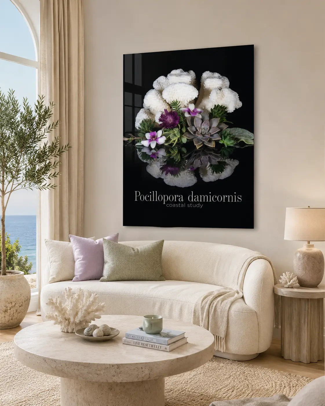 Neutral coastal living room with a curved cream sofa, soft lavender and sage accents, and a glossy frameless glass print of white coral, succulents, and small purple flowers mounted above the seating area.