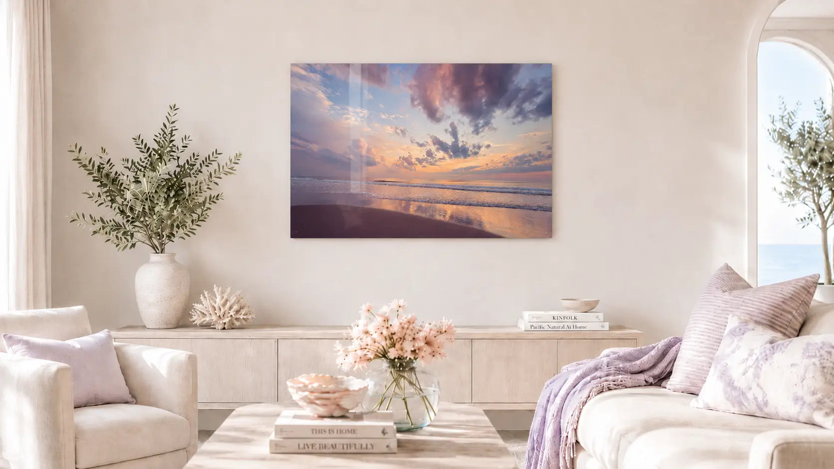 Coastal living room with a Corolla Beach Sunrise glass print, featuring soft blues, yellows and purples.