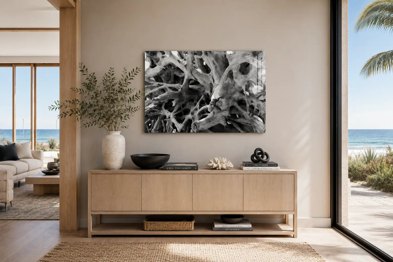 Warm modern coastal entryway with ocean views featuring Driftwood Labyrinth, a black-and-white Jekyll Island driftwood glass print above a light wood console.