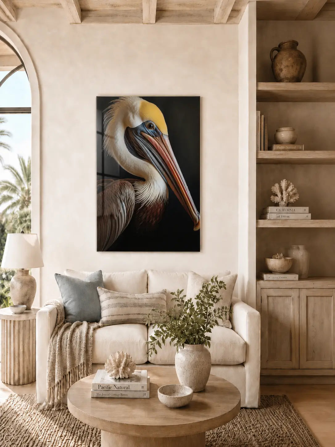 Coastal living room with a pelican art glass print on the wall, sofa, and decorative items.