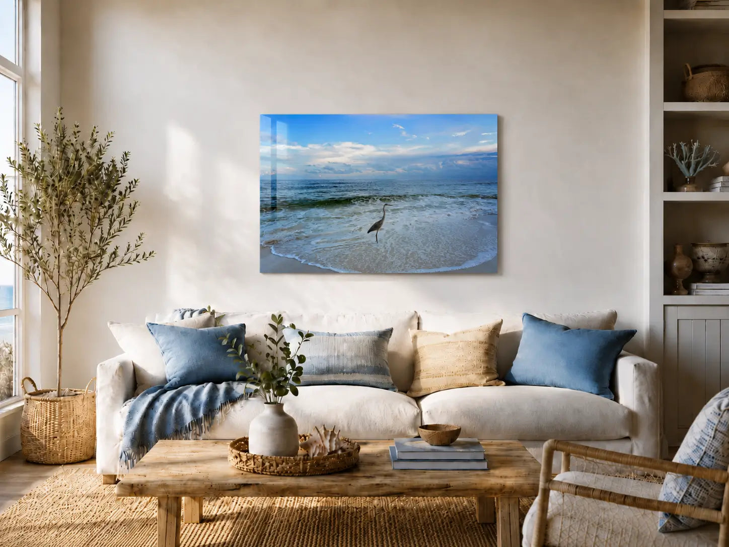 Coastal living room with a sofa, coffee table, and glass wall art of a heron at shoreline's edge