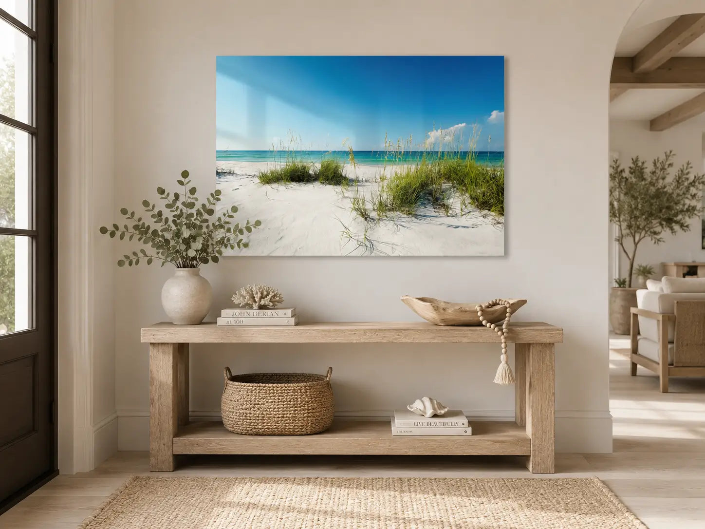 Beach scene painting on a wall above a wooden console table with decorative items.