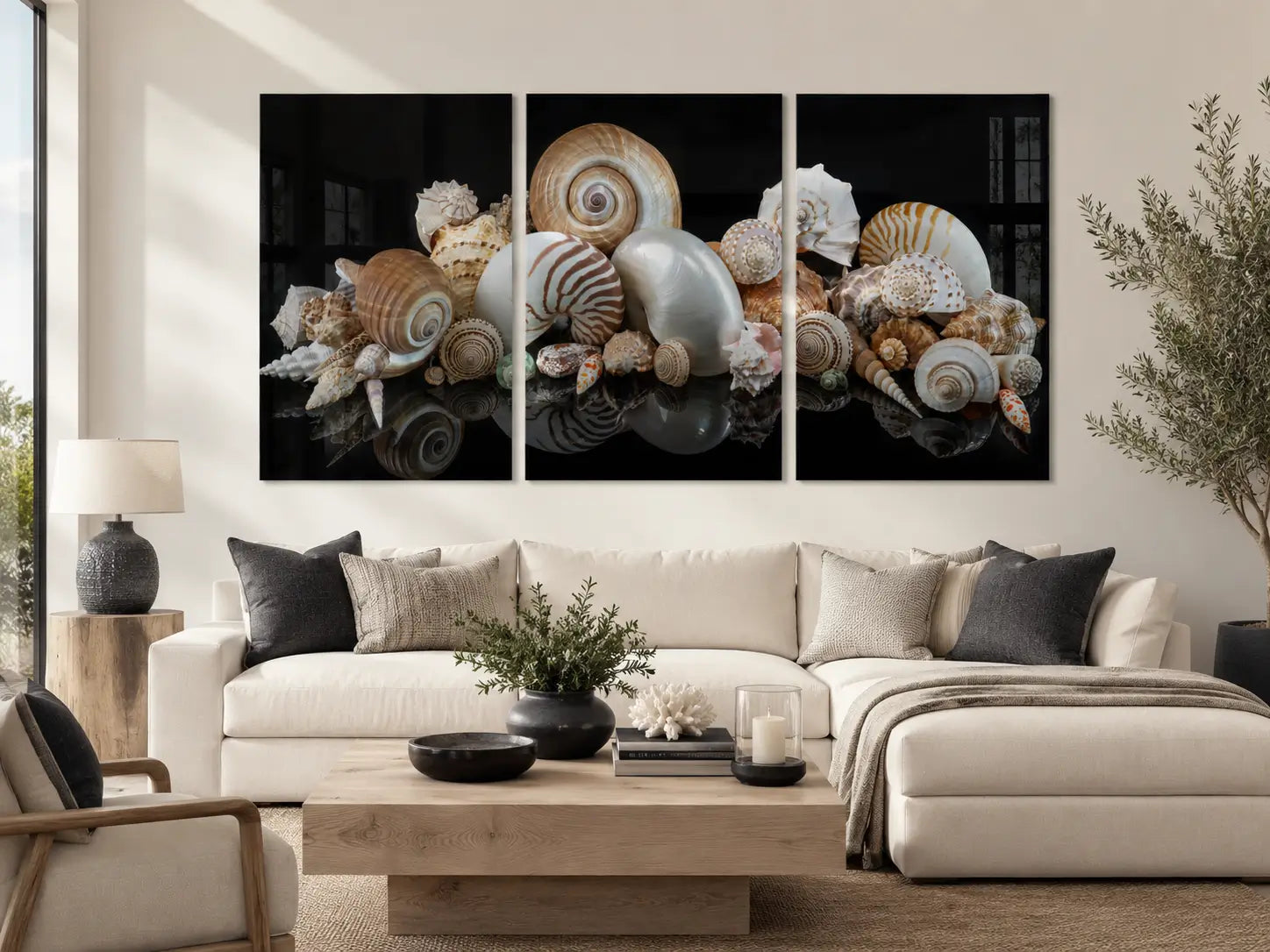 Spirals of the Sea seashell triptych glass wall art displayed above a white sectional in a modern coastal living room.